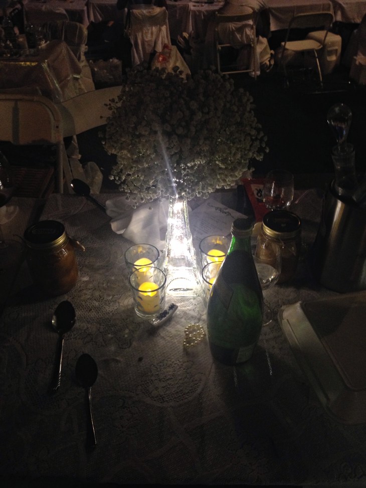 An illuminated Eiffel vase holds a bouquet of baby's breath