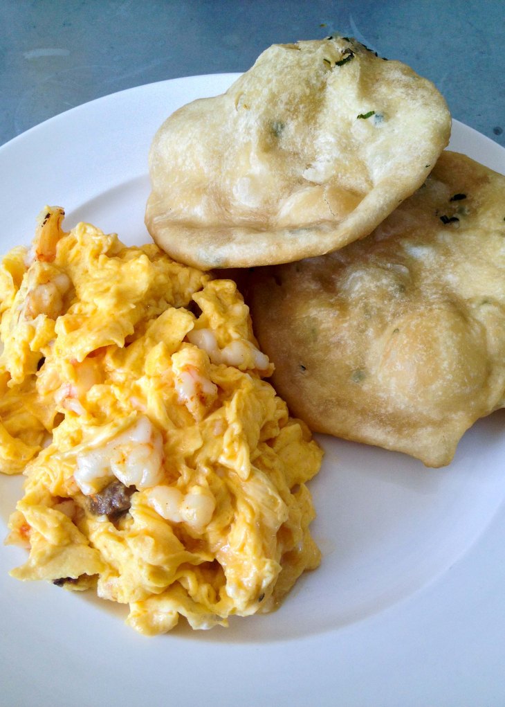 Scrambled eggs with prawns, chorizo, and hojaldre (fried bread)